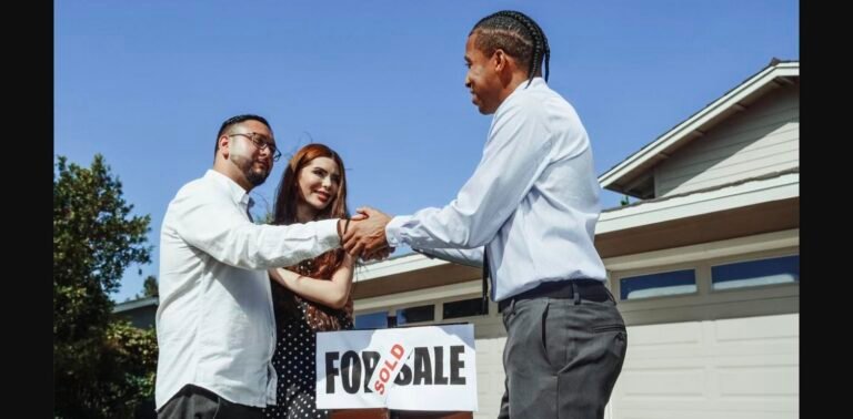 Agent commercial indépendant serrant la main de ses clients devant leur maison vendue - Izy Immobilier